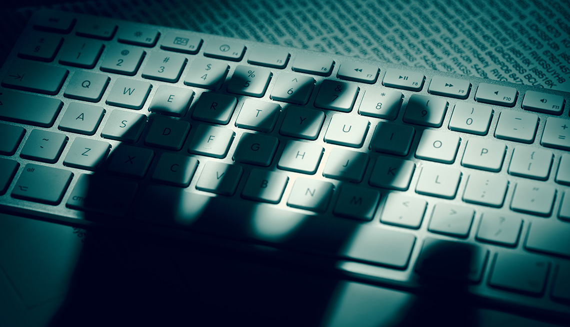 shadow of a hand on a computer keyboard