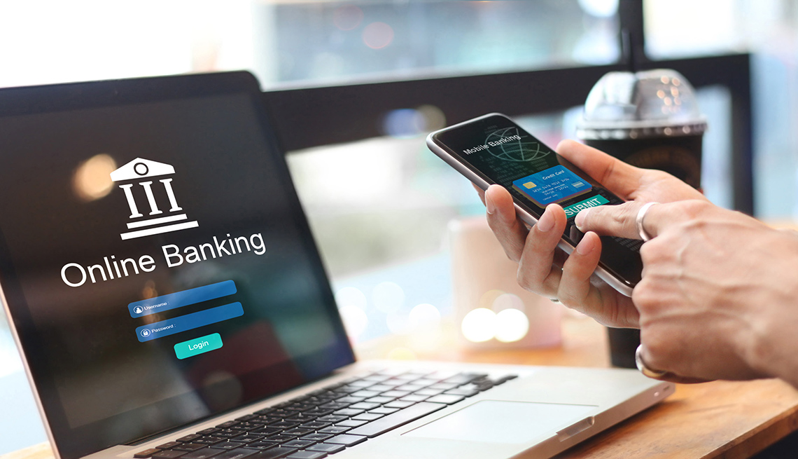 Man using online banking with credit card on touch screen device. 