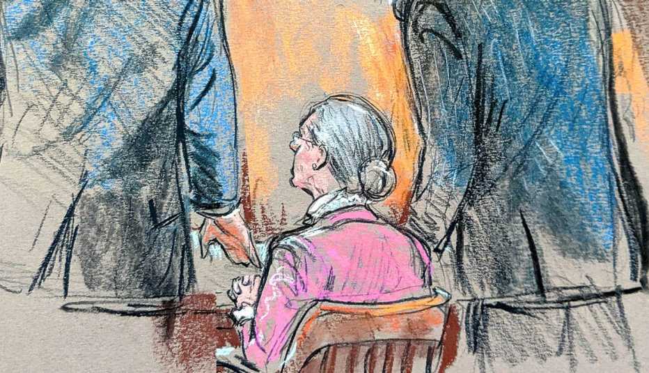 Two lawyers stand next to a woman sitting down wearing a pink sweater