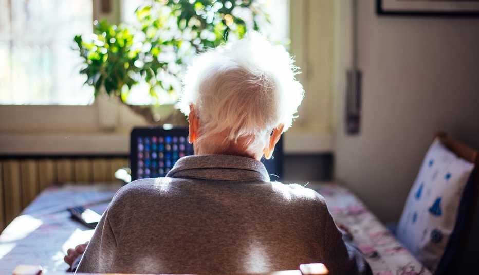 Woman alone in her room. 95 years old grandmother using laptop, and talking to the family online, through a video chat