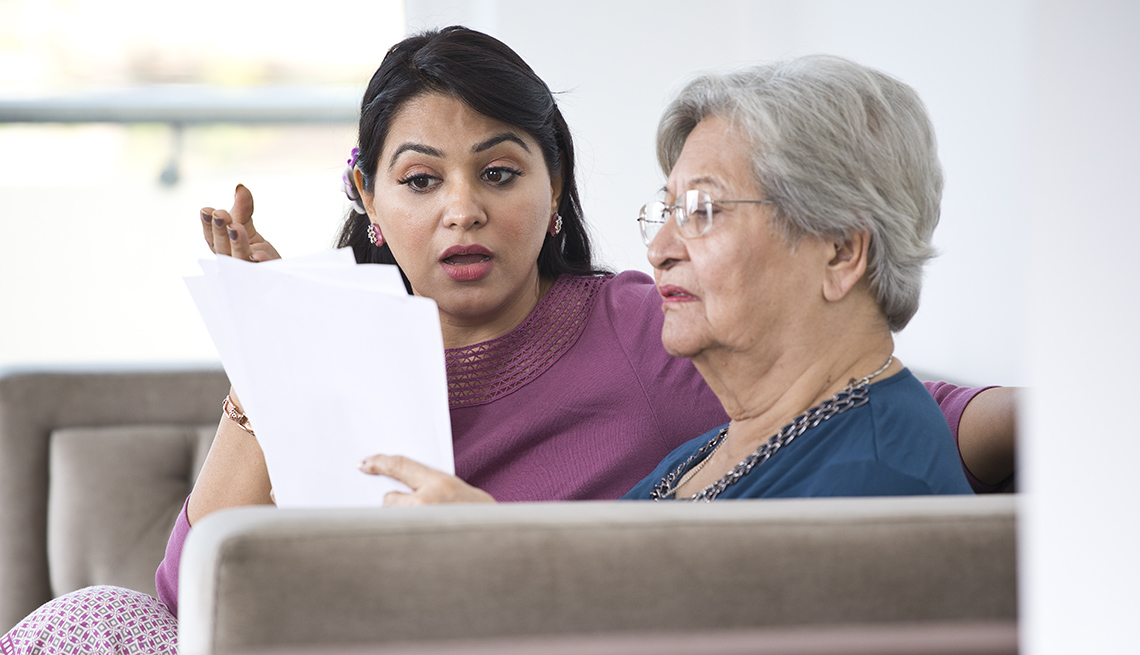  Mother and her adult daughter looking at bills