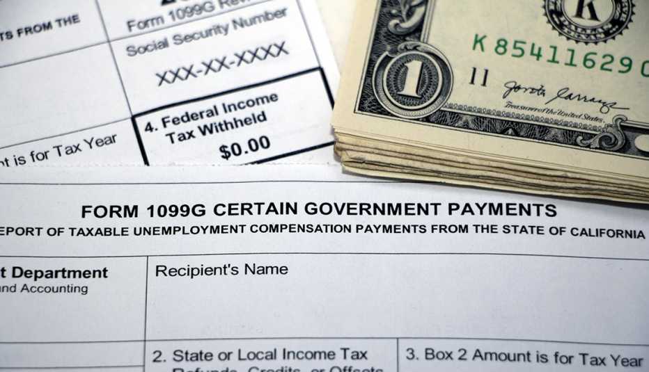 Closeup of overlapping tax forms, Form 1099G Certain Government Payments, Federal Income Tax Withheld $0.00, with stack of cash, blank form boxes.