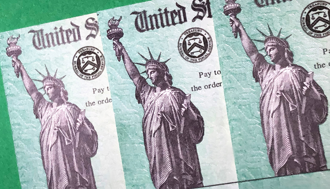 Treasury checks for coronavirus relief; Closeup view against green background
