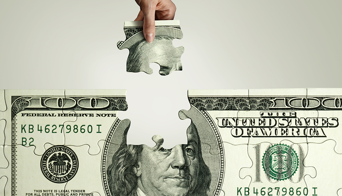 removing a piece from a 100-dollar bill jigsaw puzzle