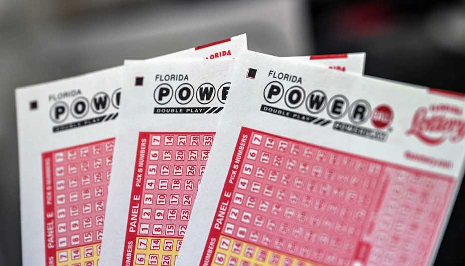 Fanned out display of the top portion of 3 powerball lottery tickets A faned out display of Powerball lottery tickets against a soft focus background