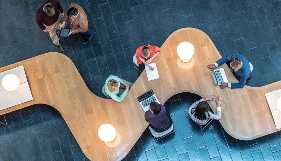 Office workers sitting at curved desk in business meeting