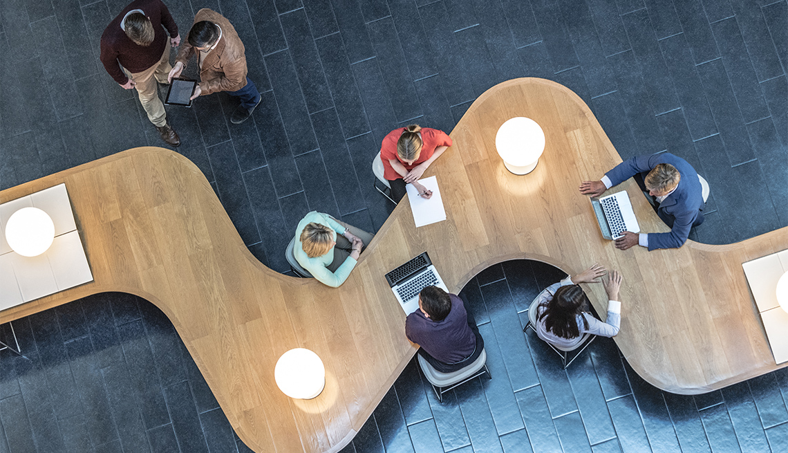 Office workers sitting at curved desk in business meeting