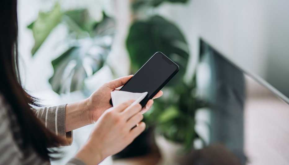 Woman cleaning her smartphone with a wipe