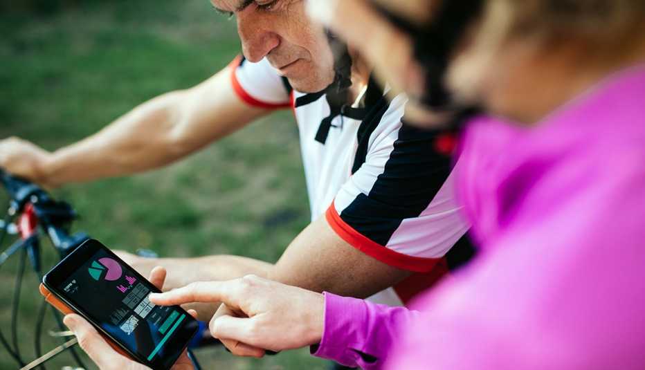closeup of biking couple checking the cycling tracking app on a smartphone