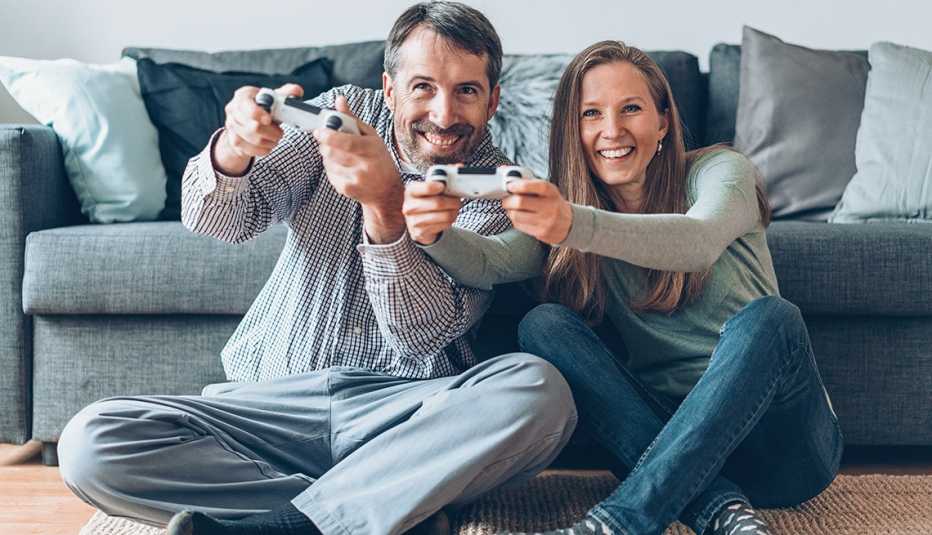 Happy couple playing video games together at home