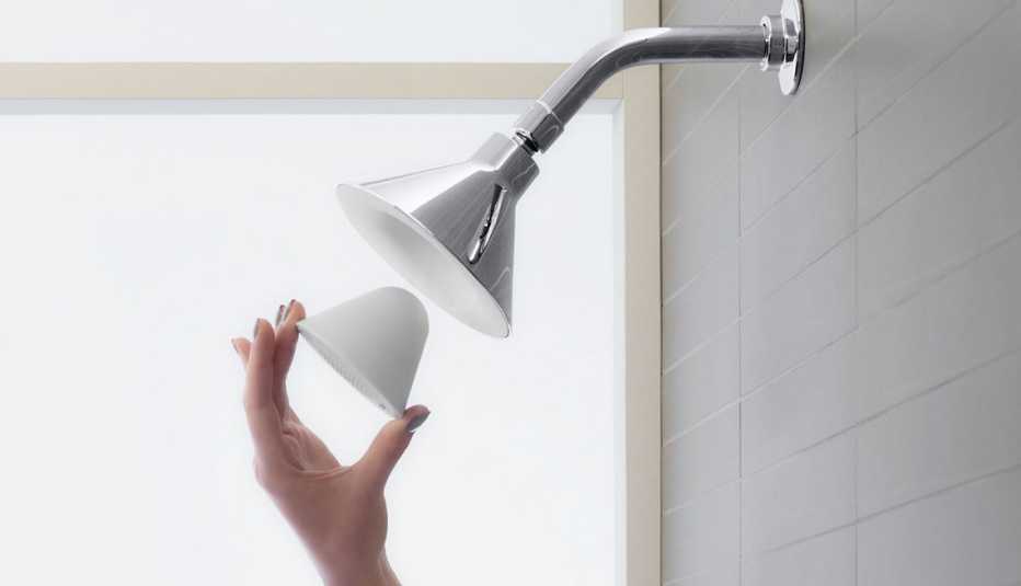 a person inserts a smart device into a shower head a person inserts a smart device into a shower head