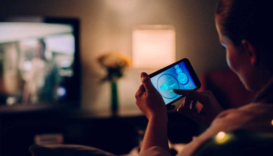 a woman controlling her household appliances with her smartphone