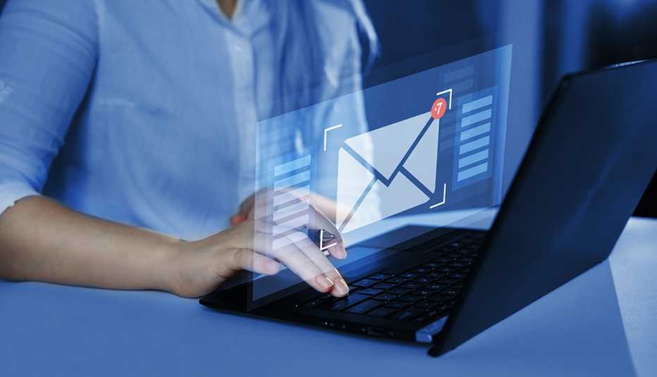 a blue hued image of a person at a keyboard with an abstract image of an email in the foreground