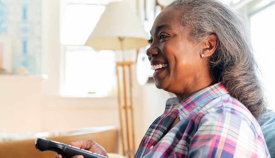 African American woman holding television remote African American woman holding television remote