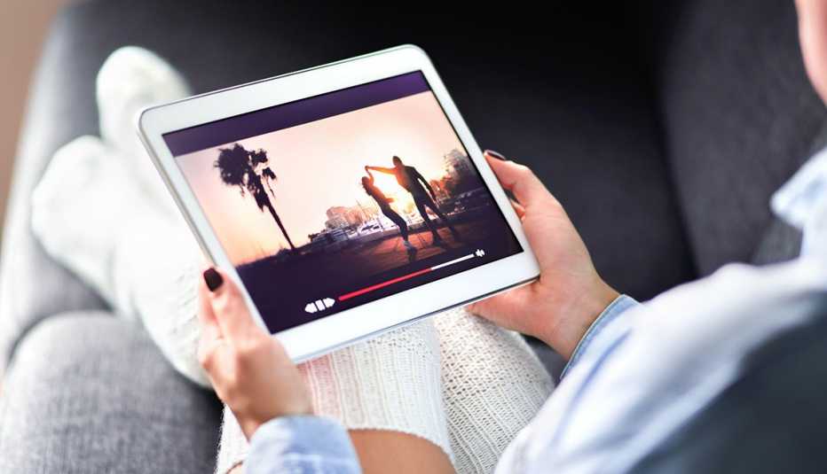 Streaming movie with VOD service. Woman watching online tv series stream. Video on demand app in tablet screen.