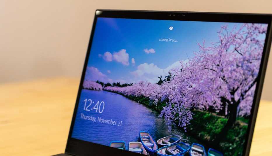 Windows lock-screen secured with Windows Hello facial recognition software as seen with ?Looking for you...? text on-screen.