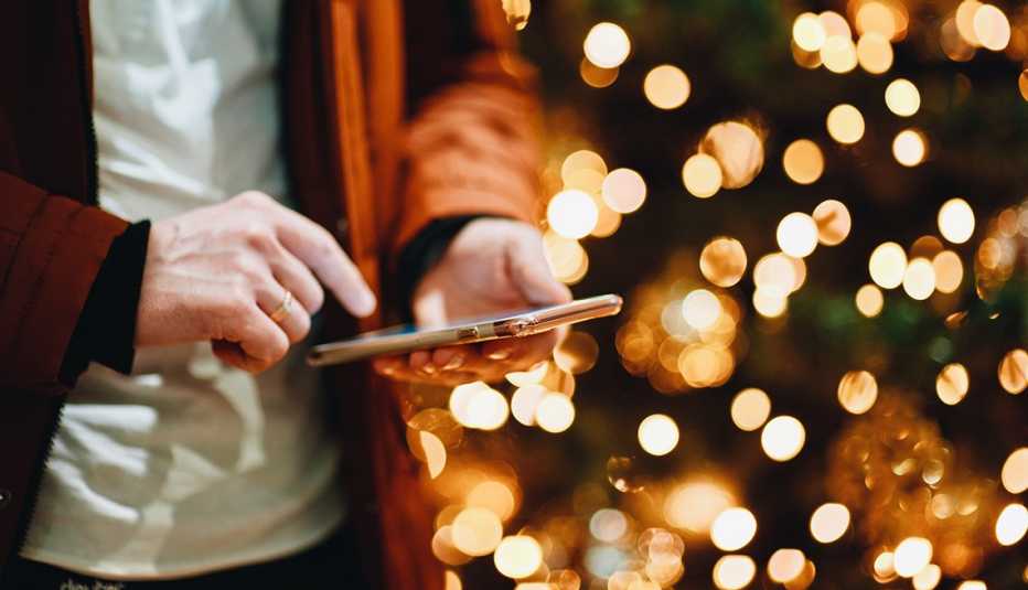 man using smartphone next to a lights display