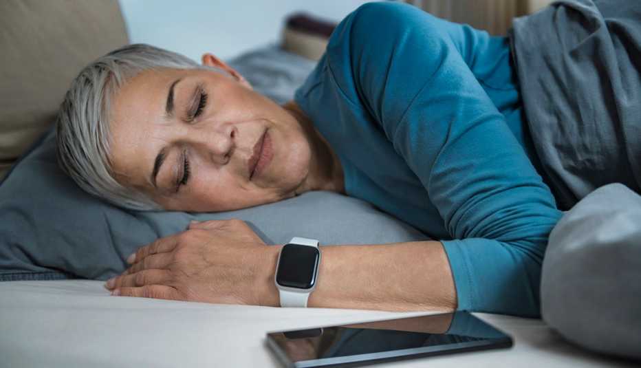 A woman is sleeping next to her smartphone