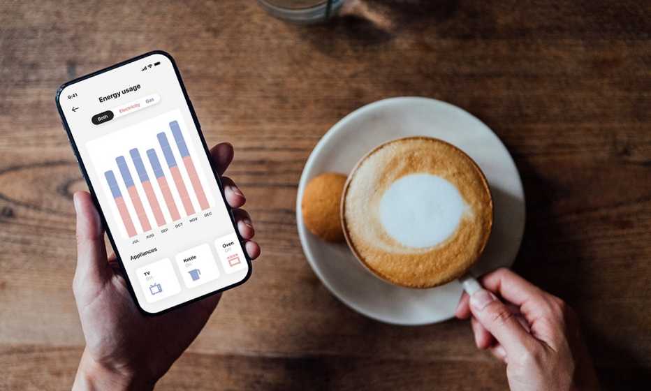 a woman checks the energy usage on her phone while drinking coffee a woman drinks coffee while checking her smartphone's energy usage
