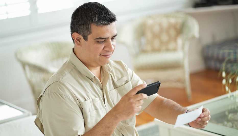man using smart phone to scan and deposit check at home