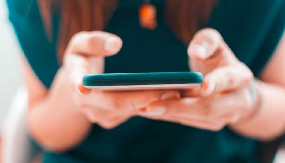 a woman in a teal outfit holds a smartphone a woman in a teal outfit holds a smartphone