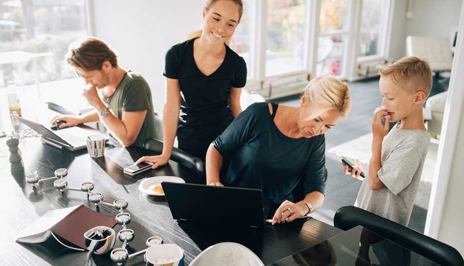 High angle view of family using technologies at dining table in room 