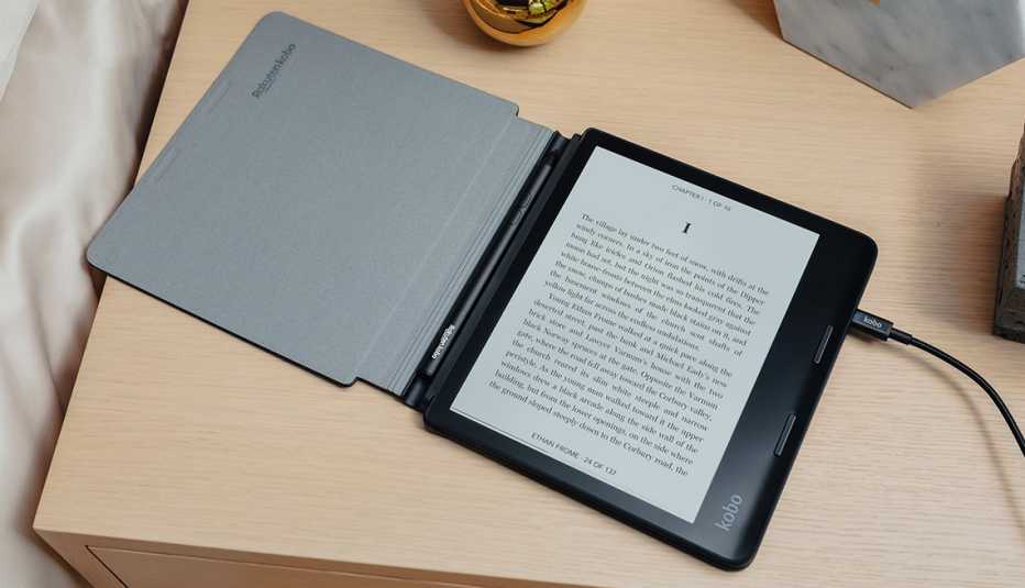 a kobo sage e reader sits charging on a nightstand