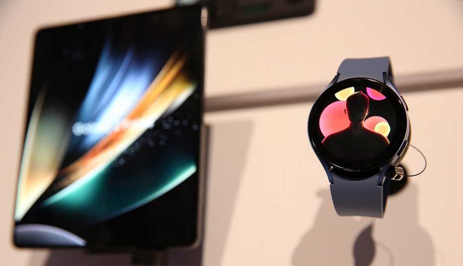 a samsung galaxy zfold4 mobile phone and a samsung galaxy watch5 on display on a white background a samsung galaxy zfold4 mobile phone and a samsung galaxy watch5 on display on a white background