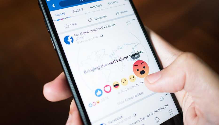 Facebook user touch on Angry button in Facebook application on iPhone 7.