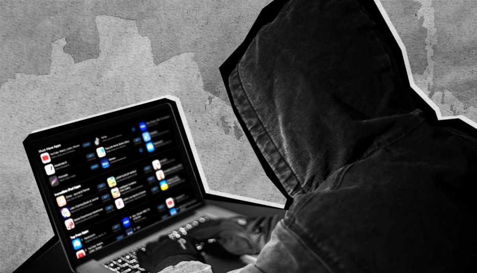 a hooded crook on a laptop a hooded criminal on a laptop