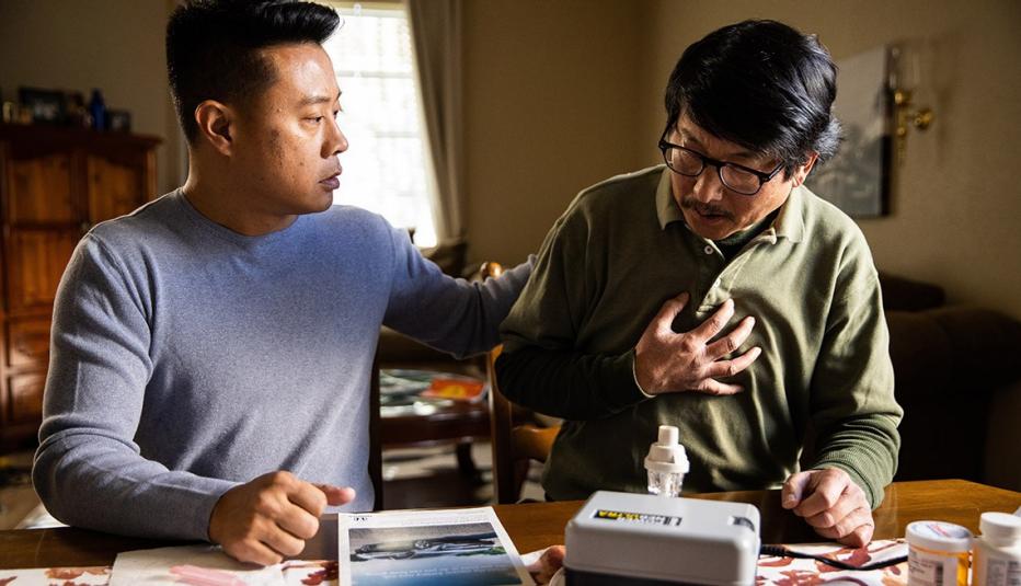 Son caregiving for his father with medical equipment Son caregiving for his father with medical equipment