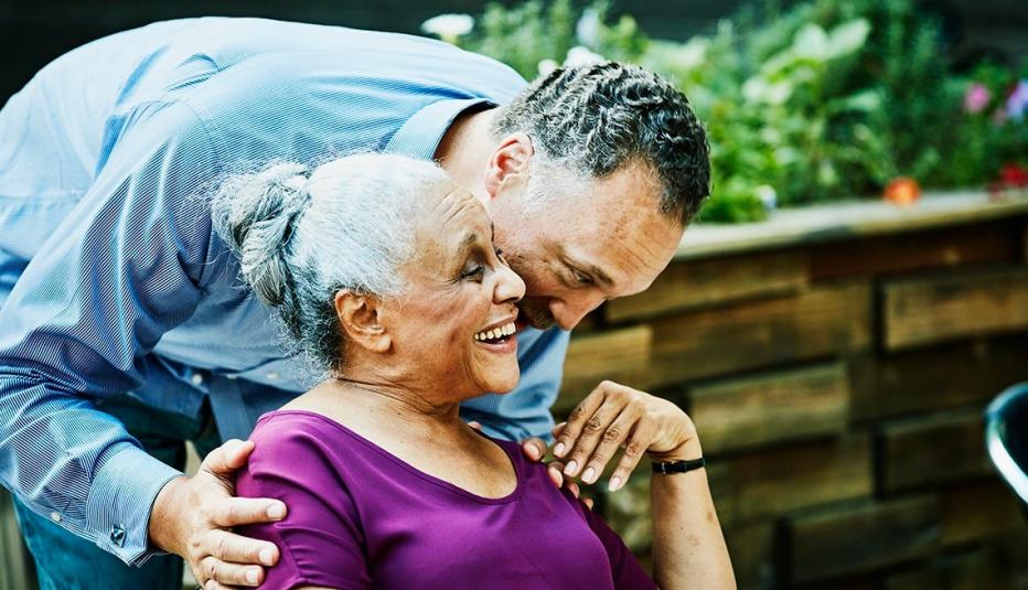 Man hugging woman sitting outside Man hugging woman sitting outside