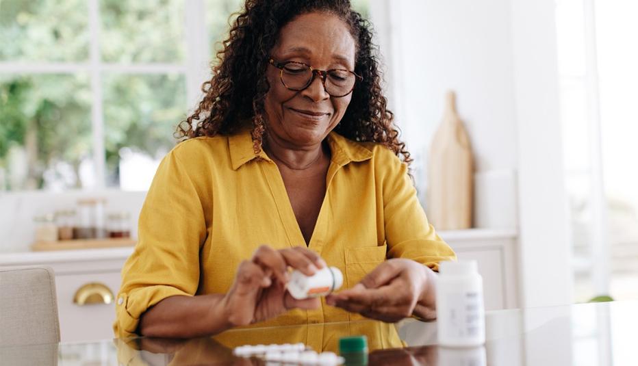 Senior woman carefully taking her prescription medication as part of her daily routine. 