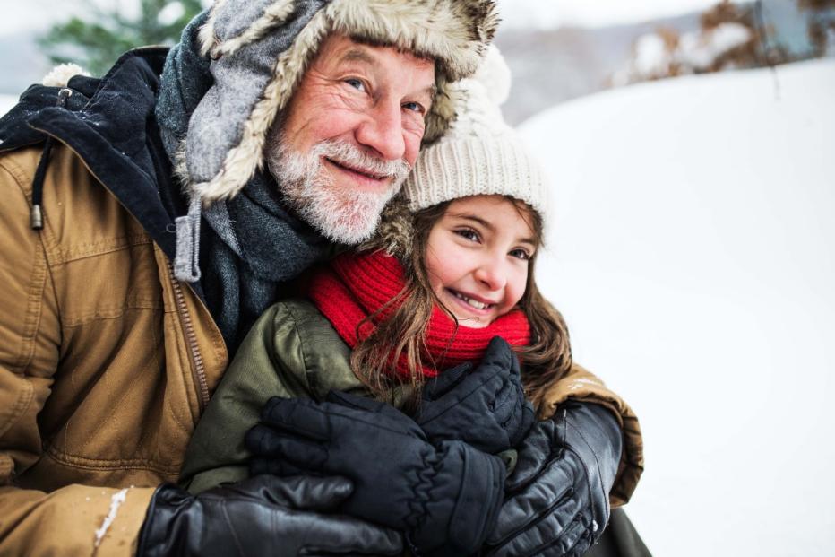 Grandfather and granddaughter in the snow