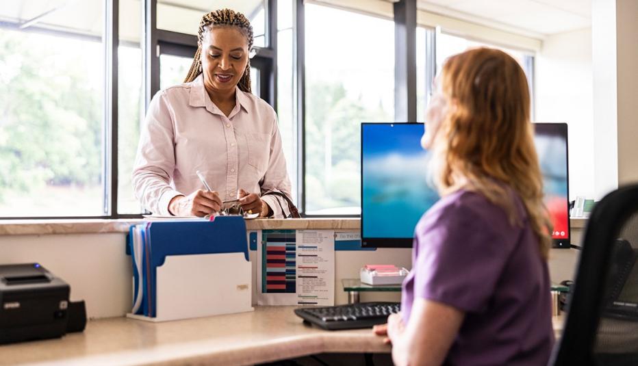 Spotlight: Enhanced Premium Tax Credit Expiration Would Threaten Affordable Health Coverage for Nearly 5 Million Midlife Adults Female patient paying with credit card at doctor's office front desk