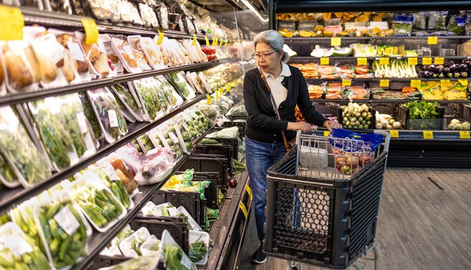 High quality stock photo of an authentic Asian-American Filipino senior woman shopping for food at a local grocery store, coping with high prices as inflation continues to push deeper into fixed incomes.