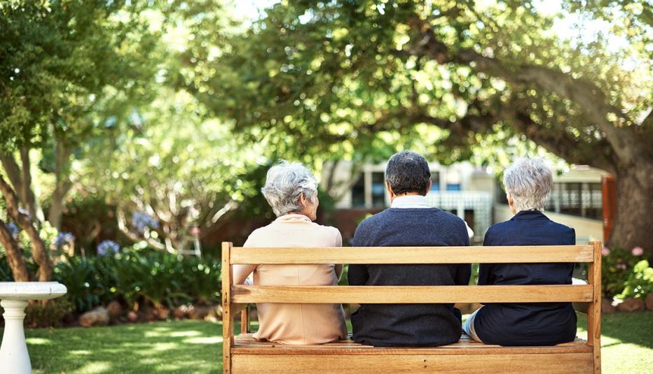 Rearview shot of a group of seniors sitting together on a bench out in the garden