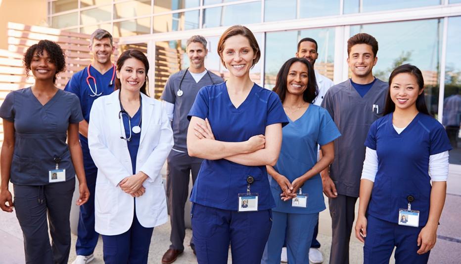 Team of healthcare workers with ID badges outside hospital