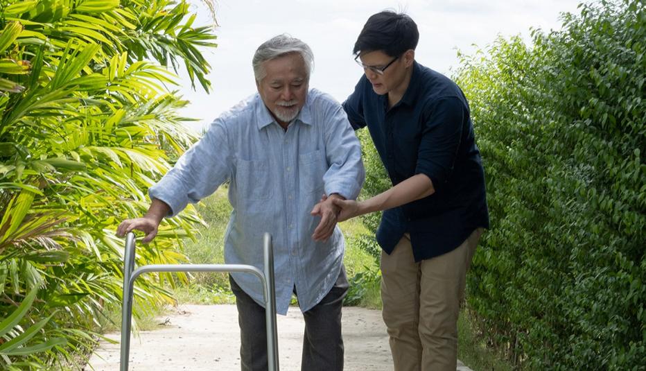 senior man walking with walker and his son