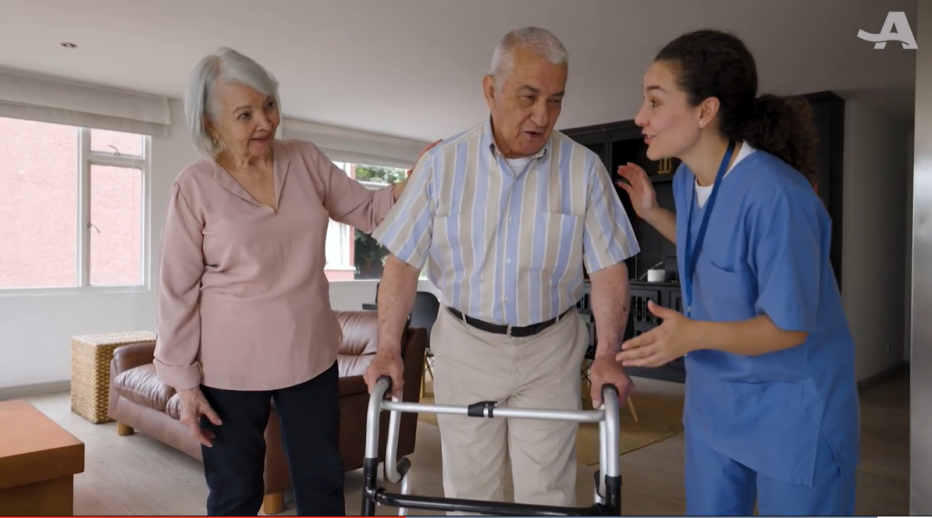Family Caregivers in Hospital at Home Models caregiver helping older man with walker with another women helping on his other side