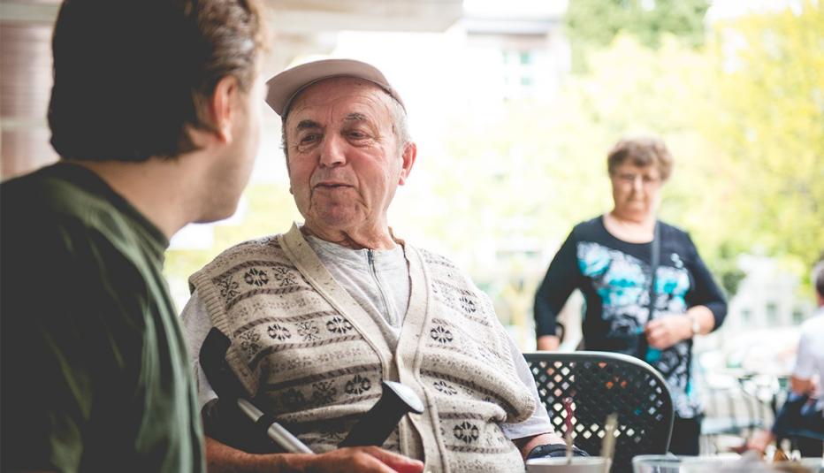 Respite Services: A Critical Support for Family Caregivers Happy Senior Man in Wheelchair and Grandson Having Coffee