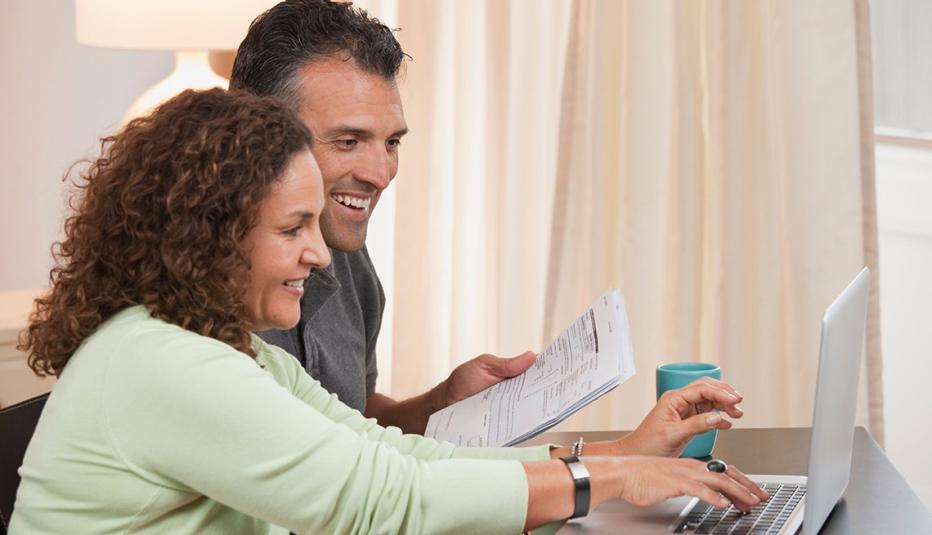 Una pareja de adultos usando una computadora portátil