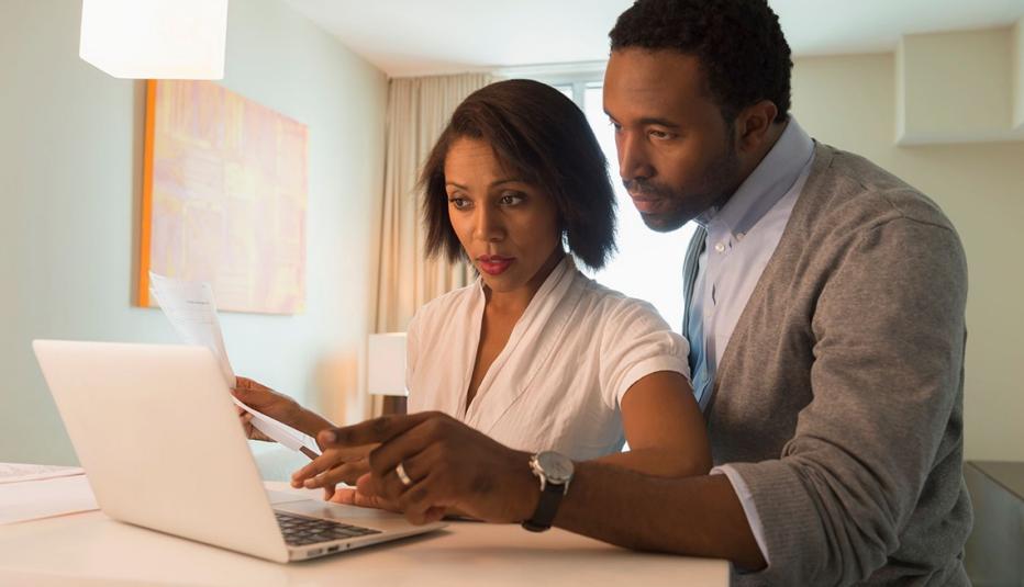 Adult couple looks at laptop