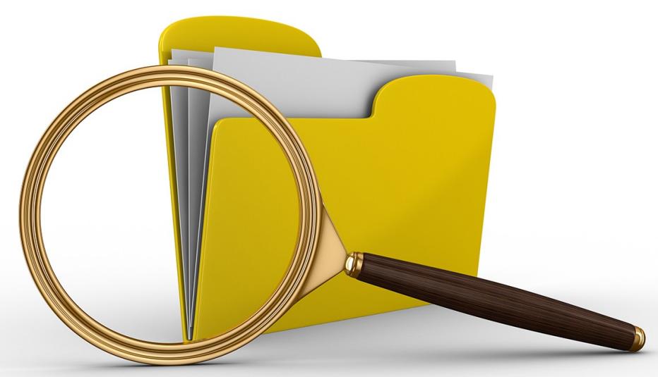 large magnifying glass in front of yellow file folder