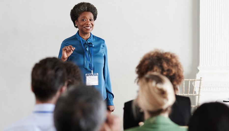 Woman in front of room speaking to a group