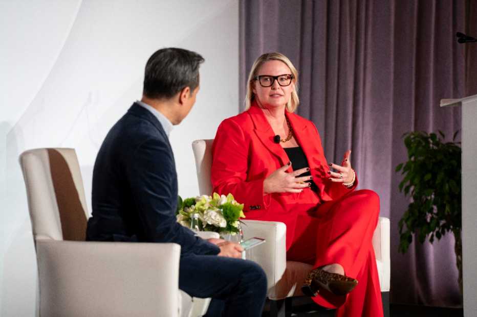 Deb Whitman speaking with another presenter in front of conference