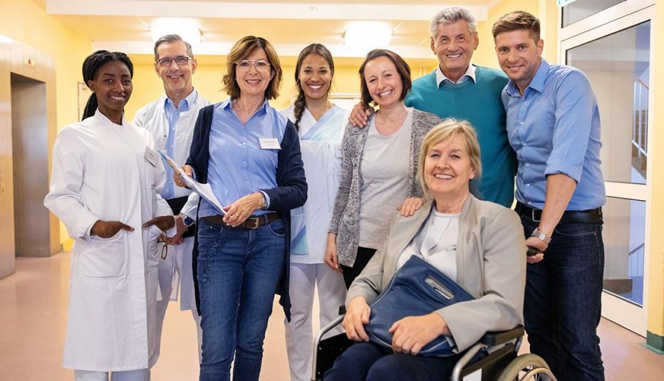Portrait of a family with healthcare professionals at rehabilitation center.