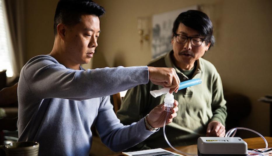 Son helping his father with nebulizer