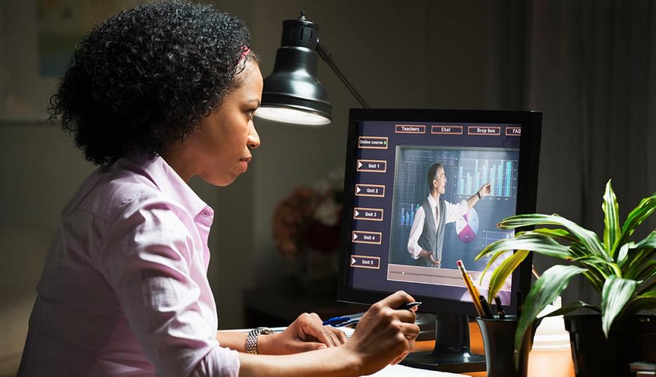 a woman looking at a computer with an online course on it