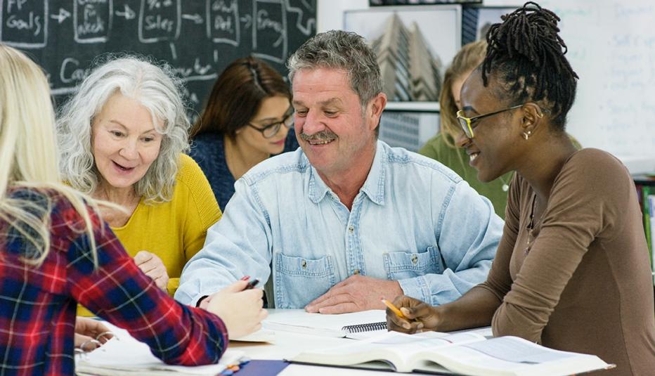 Group of adults sit around a table during a class at a college